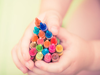 child hold colorful pencils