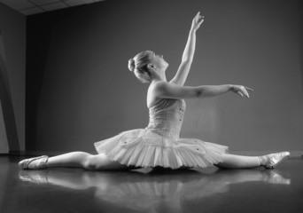 Fototapeta premium Graceful ballerina sitting with legs stretched out