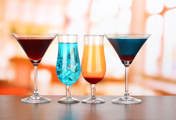 Several glasses of different drinks on bright background