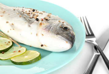 Fish dorado with lemon on plate isolated on white