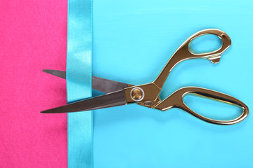 Scissors on color fabric background