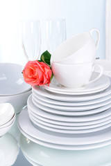 Set of white dishes on table on light background