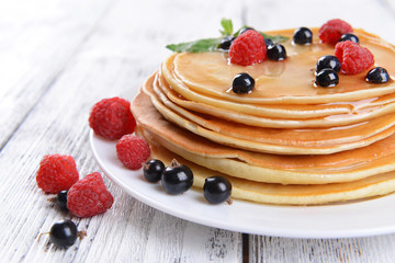 Sweet pancakes with berries on table close-up