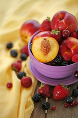 Peaches and berries in bowl on table close-up