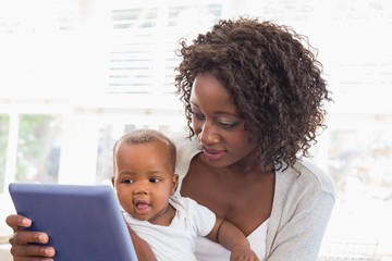 Happy mother using tablet pc with baby boy - Powered by Adobe