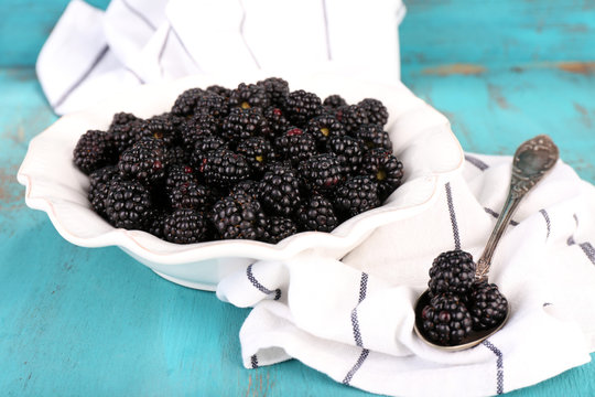Sweet blackberries on color wooden background