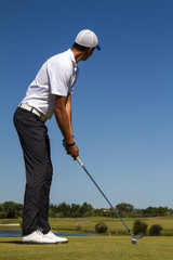 Fototapeta na wymiar Golf player hitting a golf ball in a beautiful golf course.