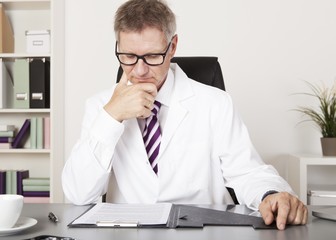 Doctor Reading Medical Results at Office