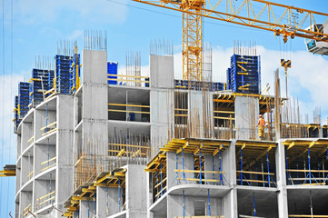 Crane and building construction site against blue sky