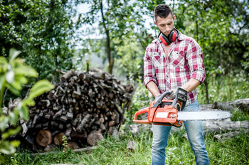 portrait of aggressive, muscular and athletic man with chainsaw