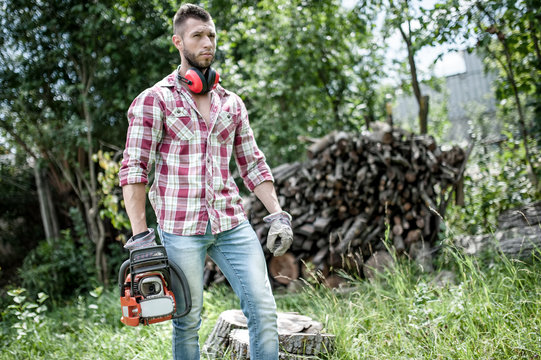 lumberjack or woodcutter moving and looking with chainsaw