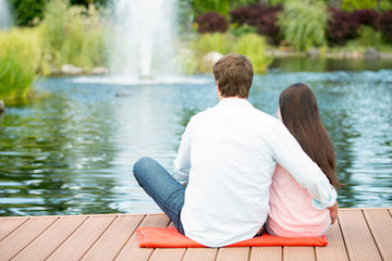 Romantic couple enjoying picnic in a park near lake