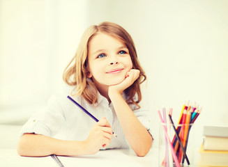 girl drawing with pencils at school