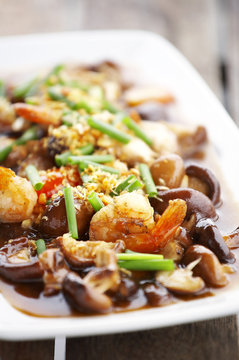 chinese food from mushroom and shrimp fried in white dish