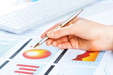 female hand pointing to the financial growth chart