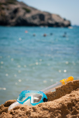 Closeup of a diving mask and snorkel on a rock at the sea