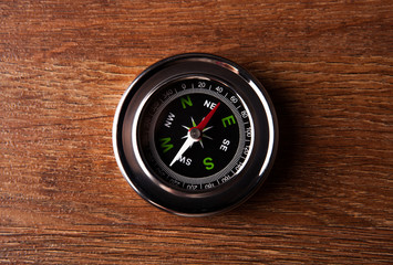 tourist compass lying on a wooden table