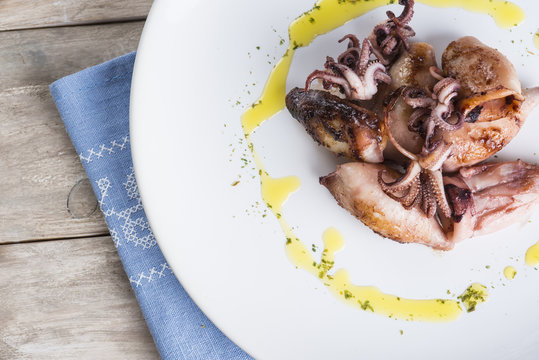 Plato cocinado de calamares a la parrilla con aceite de oliva