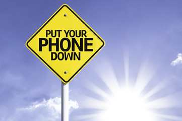 Put Your Phone Down road sign with sun background