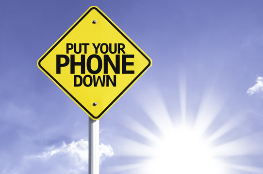 Put Your Phone Down Road Sign With Sun Background