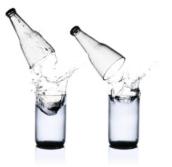 Fresh water splashing out of bottle, isolated on white backgroun