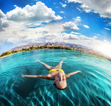 Woman swimming in the mountain lake
