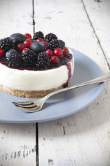 mini cheesecake with red fruits on plate with fork