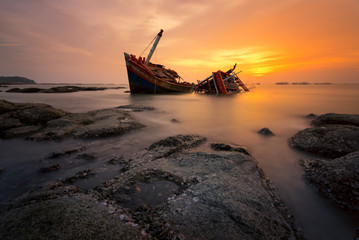 Fishing boat beached with sunset view