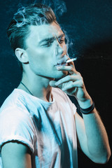 Handsome young man smoking cigarette
