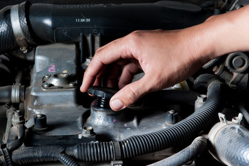 Car mechanic changing engine oil