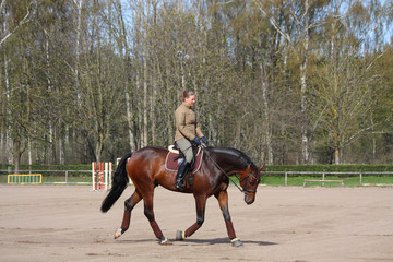 Young woman trotting on the horse