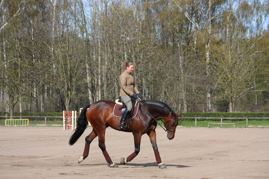 Young woman trotting on the horse