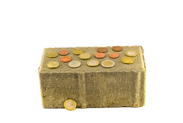gray decorative brick with money coins isolated on white