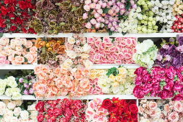 Colourful of Plastic flowers on shelf