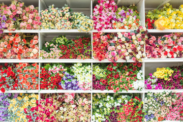 Fototapeta na wymiar Colourful of Plastic flowers on shelf