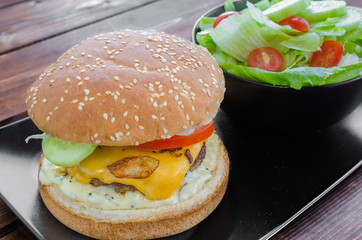 Cheeseburger with bacon and tartar sauce and garden salad