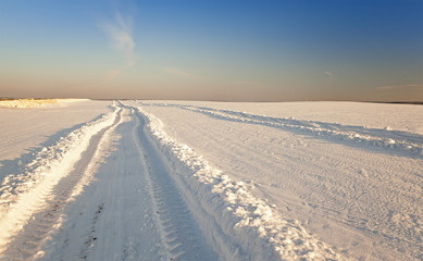  the rural road in an agricultural field in a winter season