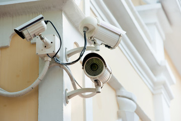 Three Security cameras frontal view on concrete wall