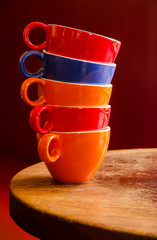 colorful coffee cups stacked on an old wooden table