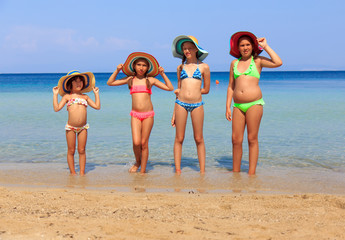 Girls with colorful hats on the beach