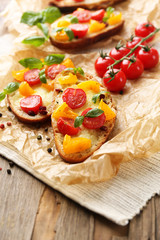 Tasty bruschetta with tomatoes, on old wooden table