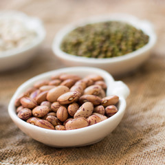 Assortment of legumes in bowls on wooden table