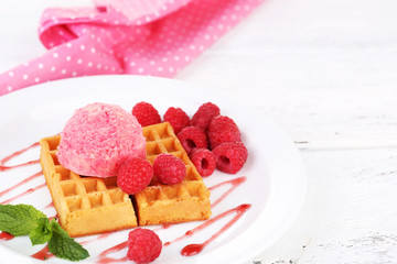 Tasty belgian waffles with ice cream on wooden table
