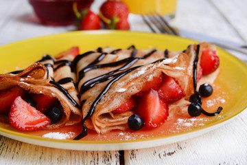 Delicious pancakes with berries on table close-up