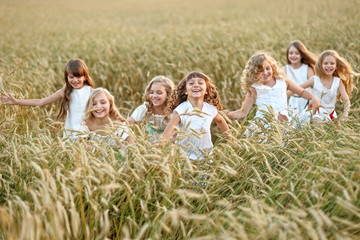 Fototapeta premium portrait of little girls running on the field
