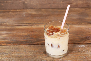 Iced coffee in glass on wooden background