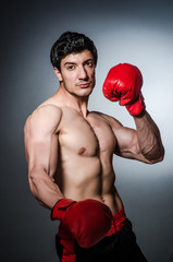 Fototapeta na wymiar Muscular boxer wiith red gloves