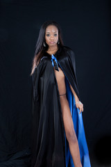 Black woman in black and blue cape,