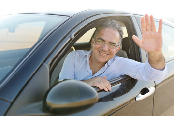 smiling man sitting in his new car