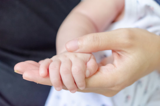 Baby  hold her mother's hand